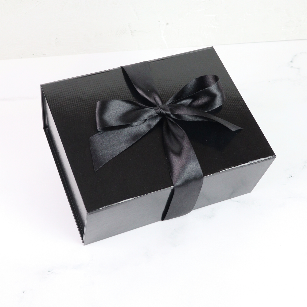 Black gift box with a black ribbon on a white background