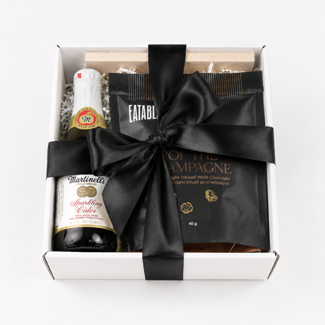 celebration gift box with black bow and popcorn, chocolate and sparkling cider