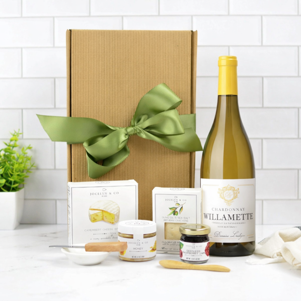 Wine bottle with a gift box and assorted items on a white surface.