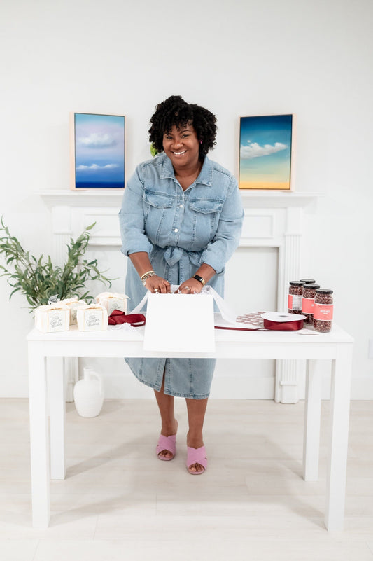 Sugarberry Gifting Co. team member hand-assembling a luxury gift box in a bright studio