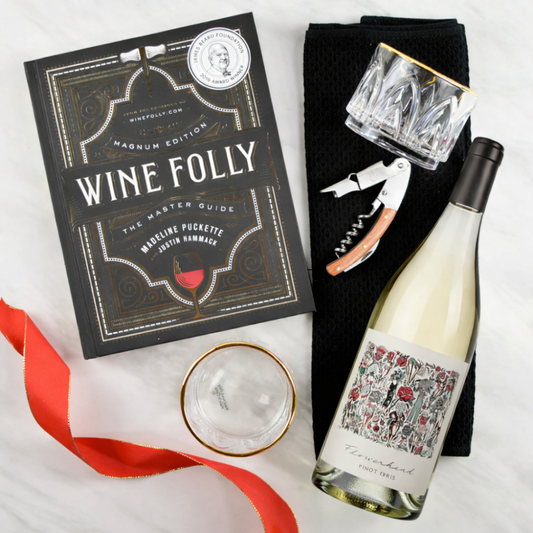 Wine bottle, 'Wine Folly' book, glasses, and corkscrew on a white background